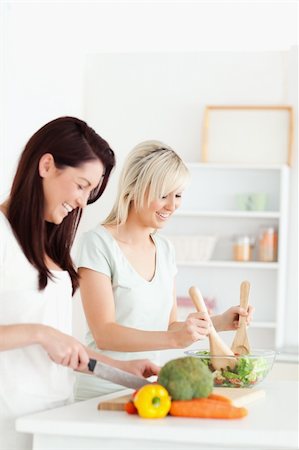 simsearch:400-05357733,k - Smiling Women preparing dinner in a kitchen Fotografie stock - Microstock e Abbonamento, Codice: 400-05357707