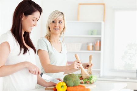 simsearch:400-05357667,k - Cheerful Women preparing dinner in a kitchen Stock Photo - Budget Royalty-Free & Subscription, Code: 400-05357703