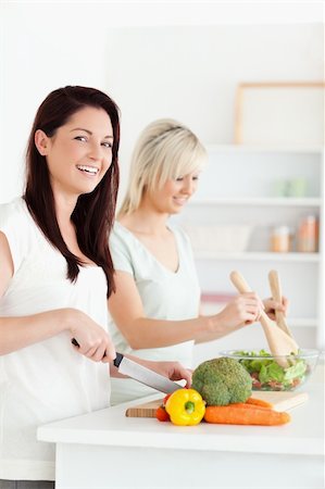 simsearch:400-05357733,k - Joyful Women preparing dinner in a kitchen Fotografie stock - Microstock e Abbonamento, Codice: 400-05357711