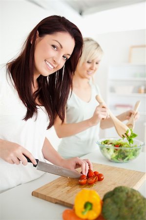 simsearch:400-05357733,k - Cute Women preparing dinner in a kitchen Fotografie stock - Microstock e Abbonamento, Codice: 400-05357724