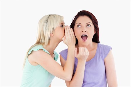 studio portrait attractive woman surprised - Portrait of a blond woman telling her friend a secret in a studio Stock Photo - Budget Royalty-Free & Subscription, Code: 400-05357847