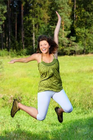 A picture of a pretty young woman jumping up high over natural green background Stock Photo - Budget Royalty-Free & Subscription, Code: 400-05358070