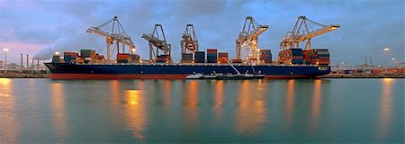 The activity of loading and unloading of huge container ships at the world's biggest and busiest container harbor in Rotterdam, just before sunset Stockbilder - Microstock & Abonnement, Bildnummer: 400-05358208