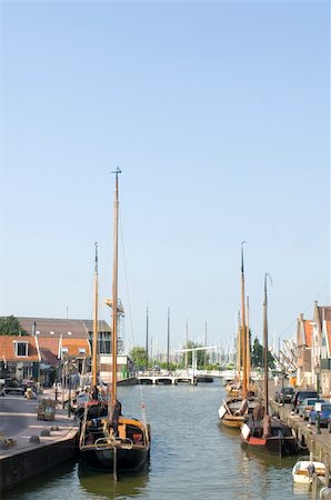 The inner harbor of Volendam, with old fishing boats moored along the quay and a draw bridge in the far end of the canal Stock Photo - Budget Royalty-Free & Subscription, Code: 400-05358676