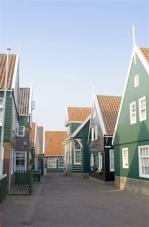 simsearch:400-05358688,k - The typical style Dutch fishermans' houses on the Peninsula of Marken. The quaint wooden gables, and the archetypal green and white paint in a deserted street during a summer evening. Foto de stock - Super Valor sin royalties y Suscripción, Código: 400-05358688