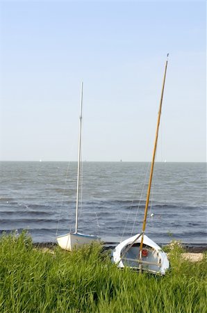 Two sailing  boats ashore on the banks of the IJsselmeer, the Netherlands on a summer evening Foto de stock - Super Valor sin royalties y Suscripción, Código: 400-05358728