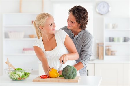 Happy couple slicing pepper in their kitchen Stock Photo - Budget Royalty-Free & Subscription, Code: 400-05350360