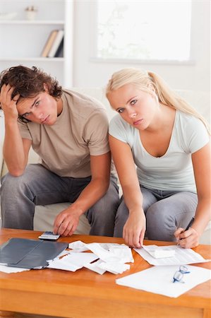 simsearch:400-05746763,k - Despaired stressed couple calculating their expenses in the living room Stock Photo - Budget Royalty-Free & Subscription, Code: 400-05350408