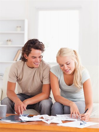 Happy couple calculating their expenses in the living room Stock Photo - Budget Royalty-Free & Subscription, Code: 400-05350409