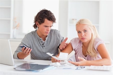 Clueless couple accounting in their living room Stock Photo - Budget Royalty-Free & Subscription, Code: 400-05350403