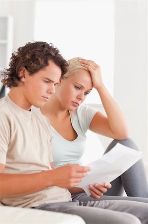 simsearch:400-05746763,k - Shocked couple reading letters in the living room Stock Photo - Budget Royalty-Free & Subscription, Code: 400-05350415