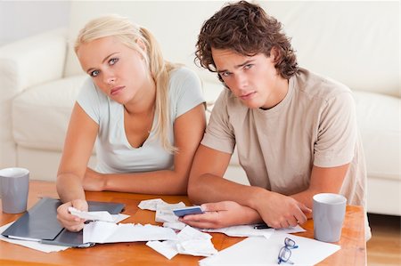simsearch:400-05746763,k - Unhappy couple looking into the camera in the living room Stock Photo - Budget Royalty-Free & Subscription, Code: 400-05350411