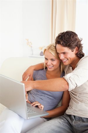 Portrait of a man showing something to his wife on a notebook in their living room Stock Photo - Budget Royalty-Free & Subscription, Code: 400-05350508