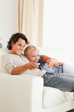 elegant tv room - Portrait of a laughing couple cuddling while watching TV in their living room Stock Photo - Budget Royalty-Free & Subscription, Code: 400-05350529