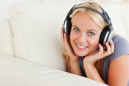 simsearch:400-04418454,k - Blonde woman enjoying some music while looking at the camera Foto de stock - Royalty-Free Super Valor e Assinatura, Número: 400-05350540