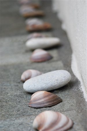 Line up of shells and stones on side of bathtub. Spa Objects Foto de stock - Royalty-Free Super Valor e Assinatura, Número: 400-05350904