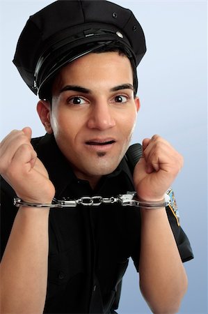 Crazy policeman with hands in handcuffs arrest. Stock Photo - Budget Royalty-Free & Subscription, Code: 400-05351119