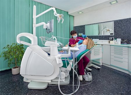Female dentist working on patient in modern dental surgery Photographie de stock - Aubaine LD & Abonnement, Code: 400-05352201
