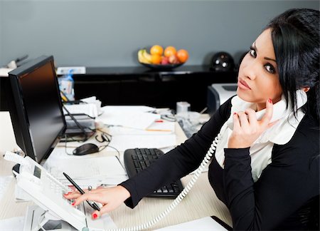 young hispanic female speaking on a phone in the office Stock Photo - Budget Royalty-Free & Subscription, Code: 400-05352243
