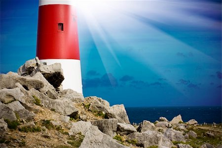 Lighthouse on rocks with light beams Foto de stock - Royalty-Free Super Valor e Assinatura, Número: 400-05353309