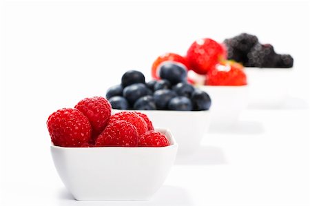 photos of blueberries for kitchen - raspberries in front of wild berries in bowls on white background Stock Photo - Budget Royalty-Free & Subscription, Code: 400-05353669