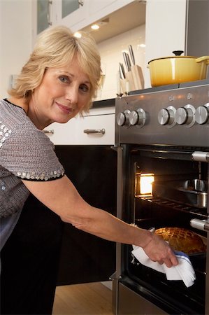 simsearch:400-05364217,k - Woman Taking Food Out Of The Oven Stockbilder - Microstock & Abonnement, Bildnummer: 400-05364209