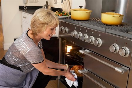 simsearch:400-05364217,k - Woman Taking Food Out Of The Oven Stockbilder - Microstock & Abonnement, Bildnummer: 400-05364211