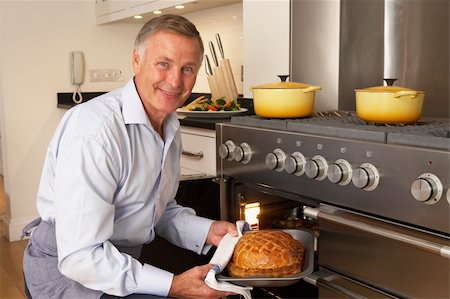 simsearch:400-05364217,k - Man Taking Food Out Of The Oven Stockbilder - Microstock & Abonnement, Bildnummer: 400-05364213