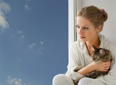 young beautiful girl with a cat in her arms looking out the window Stock Photo - Budget Royalty-Free & Subscription, Code: 400-05367953