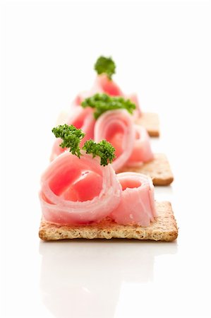 photo of delicious crackers with ham and parsley on white background Foto de stock - Super Valor sin royalties y Suscripción, Código: 400-05368339