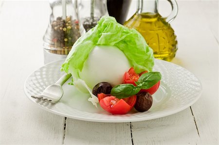 delicious buffalo mozzarella with wrapped lettuce and tomatoes on wooden table Stock Photo - Budget Royalty-Free & Subscription, Code: 400-05368350