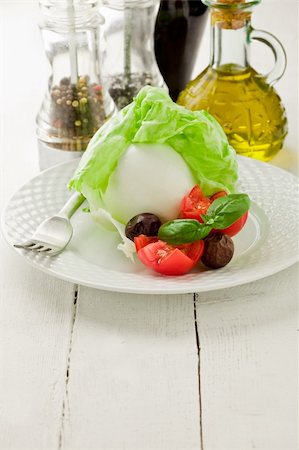 delicious buffalo mozzarella with wrapped lettuce and tomatoes on wooden table Stock Photo - Budget Royalty-Free & Subscription, Code: 400-05368351