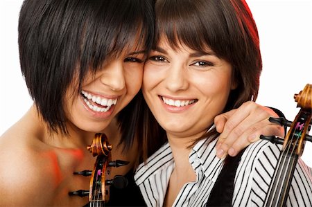 Two beautiful girls cheek-to-cheek smiling and hugging holding violins Stock Photo - Budget Royalty-Free & Subscription, Code: 400-05360418