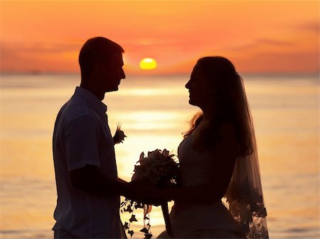 Shape of a bride and groom on the beach at sunrise time Stockbilder - Microstock & Abonnement, Bildnummer: 400-05363800