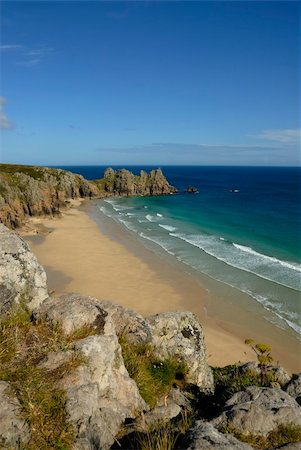 simsearch:400-04469411,k - Pedn vounder beach, one of Cornwall's best beaches with stunning cliffs of Treryn Dinas, crystal clear water and a beautiful sandy beach.      On a spring low tide one can walk to Pedn Vounder from neighbouring Porthcurno beach but be warned, as the tide comes in you will not only find yourself cut off but facing a climb up the steep cliff "path"      The headland to the east of the beach is the l Photographie de stock - Aubaine LD & Abonnement, Code: 400-05377539
