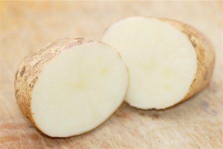simsearch:400-04806843,k - One Kestrel potato cut in half on chopping board. Focus on first half. Photographie de stock - Aubaine LD & Abonnement, Code: 400-05377579