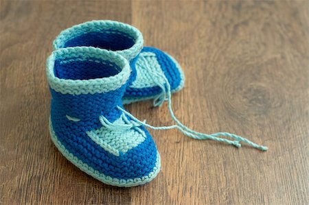 Knitted handmade baby's bootees on wood floor Stockbilder - Microstock & Abonnement, Bildnummer: 400-05370252