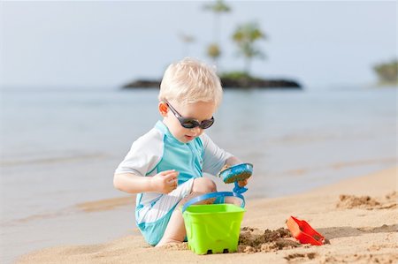 shovel in dirt - adorable toddler playing in sand on a tropical beach Foto de stock - Super Valor sin royalties y Suscripción, Código: 400-05384034