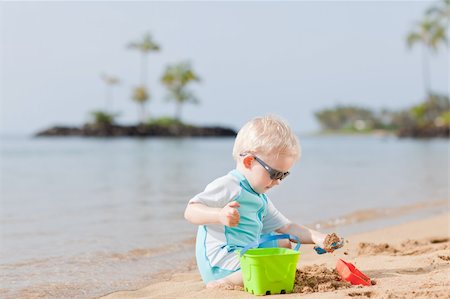 shovel in dirt - adorable toddler playing in sand on a tropical beach Foto de stock - Super Valor sin royalties y Suscripción, Código: 400-05384035