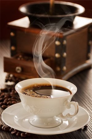 Cup of coffee in front of vintage coffee grinder. Foto de stock - Super Valor sin royalties y Suscripción, Código: 400-05384542