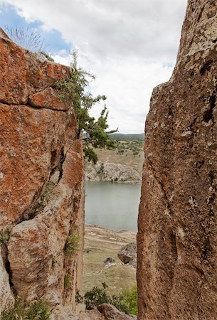 portrait looking through a gorge of a tarn lake in Cappadocia, Turkey, clouds, blue sky, crop space, copy space and vertical Photographie de stock - Aubaine LD & Abonnement, Code: 400-05384575