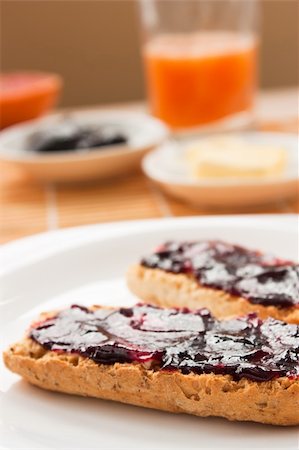 spreading butter on bread - Breakfast with butter and jam and freshly squeezed juice. Stock Photo - Budget Royalty-Free & Subscription, Code: 400-05384751