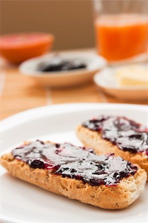 spreading butter on bread - Breakfast with butter and jam and freshly squeezed juice. Stock Photo - Budget Royalty-Free & Subscription, Code: 400-05384752