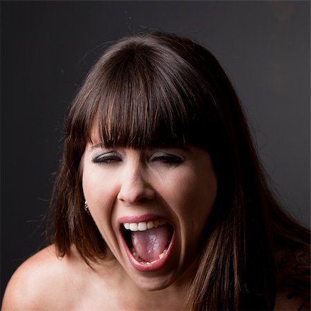 portrait screaming girl - Close-up portrait of a desperate woman shouting with something, against a grey background Stock Photo - Budget Royalty-Free & Subscription, Code: 400-05385573