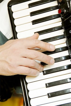 musician hand playing accordion closeup in dramatic shadows Photographie de stock - Aubaine LD & Abonnement, Code: 400-05385689