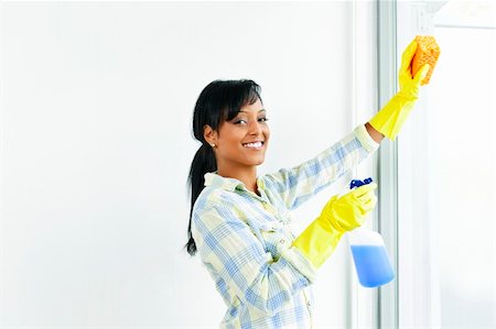 simsearch:700-01083983,k - Smiling black woman cleaning windows with glass cleaner Stock Photo - Budget Royalty-Free & Subscription, Code: 400-05386033