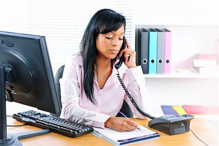 simsearch:695-03381231,k - Serious young black business woman on phone taking notes in office Photographie de stock - Aubaine LD & Abonnement, Code: 400-05386064