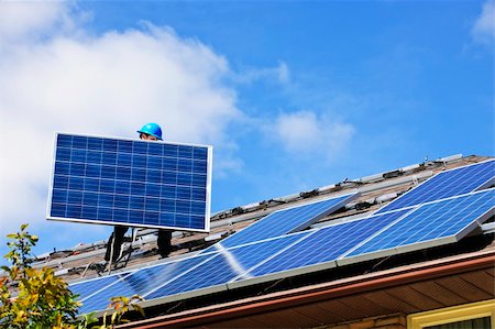 simsearch:400-05380326,k - Worker installing alternative energy photovoltaic solar panels on roof Stock Photo - Budget Royalty-Free & Subscription, Code: 400-05386121