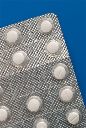 simsearch:400-05135660,k - Close-up of a pack of white pills on blue background. Stockbilder - Microstock & Abonnement, Bildnummer: 400-05386973