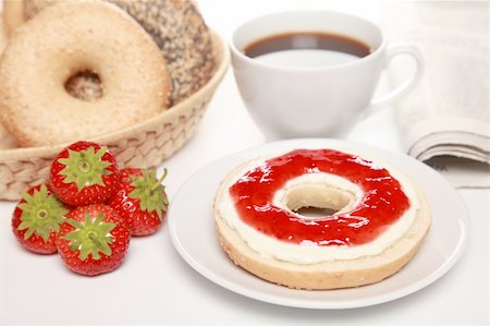 Breakfast with fresh bagels served with cream cheese, strawberry marmalade, coffee and a newspaper Stock Photo - Budget Royalty-Free & Subscription, Code: 400-05387533